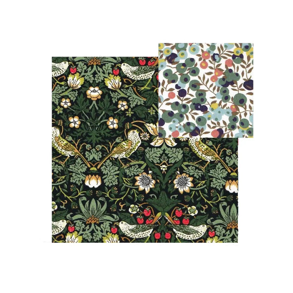 Two square fabric or paper napkins with botanical and bird patterns, shown on a plain white background. One napkin has a dark green background with cream, yellow, red, and blue floral and bird motifs.