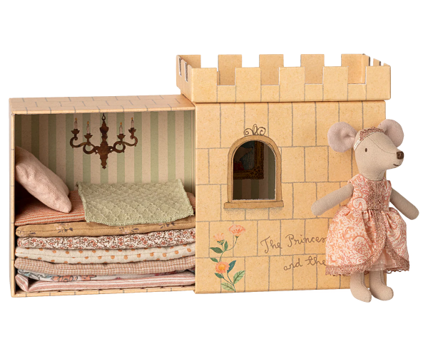 Wooden castle toy with bedding and a mouse doll in a dress on a white background