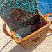 Woven basket with patterned fabric lining by a poolside