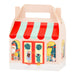 A Christmas-themed paper gift box with a handle, featuring a red and mint green striped awning and festive storefront illustrations on a white background.