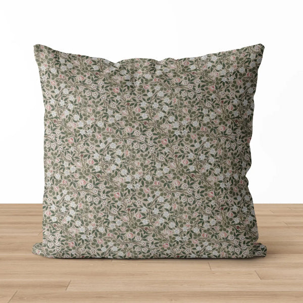 Floral patterned pillow on a wooden surface with a white background