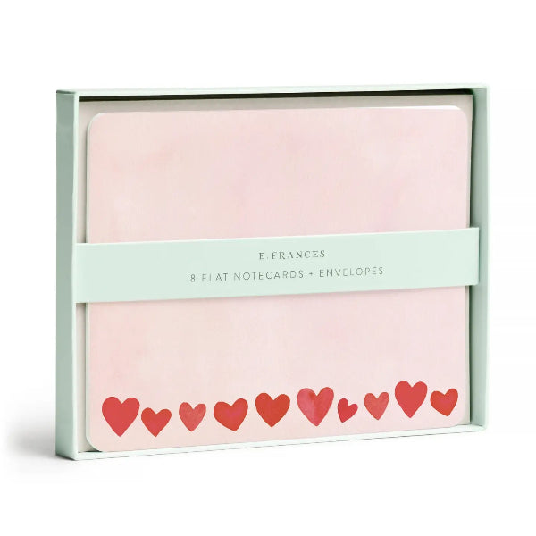 Pack of flat notecards with envelopes featuring red hearts on a pink background, branded 'E. Frances'.