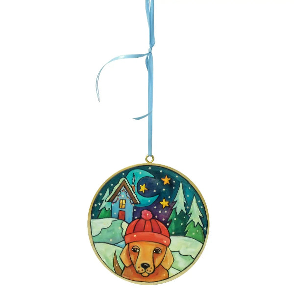 Decorative hanging ornament with a dog wearing a red hat in a snowy landscape.