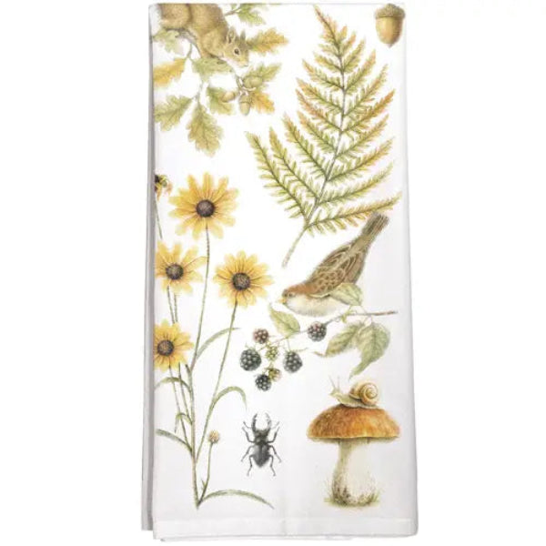 A white kitchen towel featuring a vintage-style botanical and nature print with a fern, sunflowers, a bird, a mushroom, a snail, a beetle, and acorns.