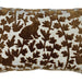 A close-up of a decorative throw pillow featuring a brown velvet embroidered pattern of rabbits and leafy vines on a textured cream fabric background.