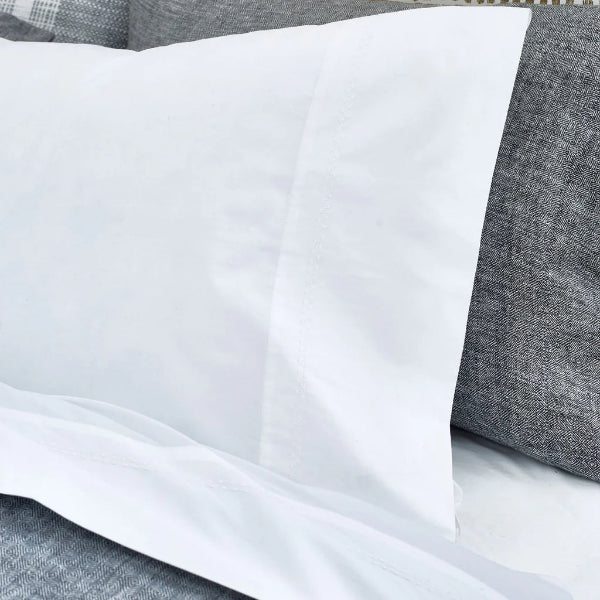 White pillowcase on a gray pillow with a textured fabric background
