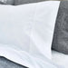 White pillowcase on a gray pillow with a textured fabric background