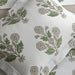 White bedding set with a botanical floral pattern in muted green and taupe, featuring a pillowcase and matching sheets.