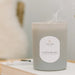 Candle labeled 'Cashmere' by LINNEA on a surface with a blurred background