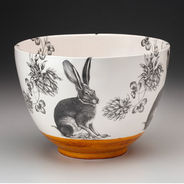 Ceramic bowl with rabbit and floral design on a white background
