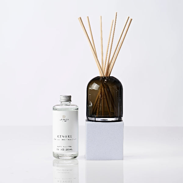 Diffuser with wooden sticks and bottle labeled 'Hinoki' on a white background