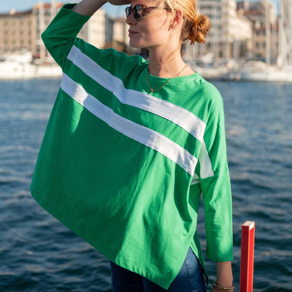 Woman wearing a green shirt with white stripes by a waterfront