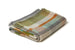 A folded woven blanket with a multicolor striped pattern in shades of green, orange, blue, gray, and beige, set against a plain white background.