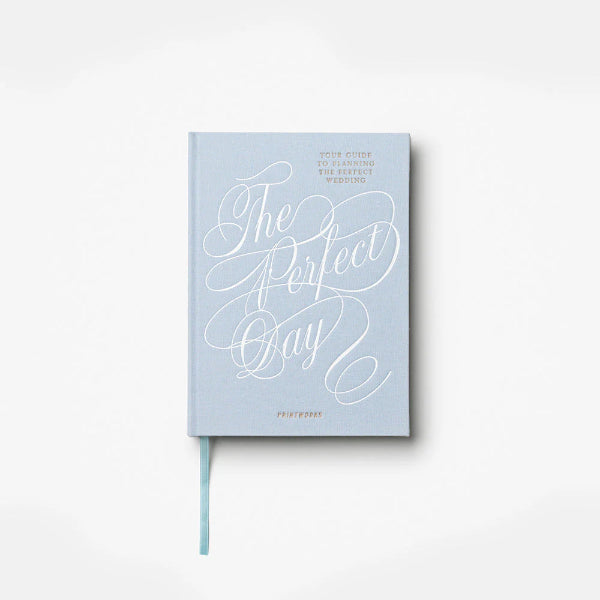 Light blue notebook with 'The Perfect Day' text on a white background