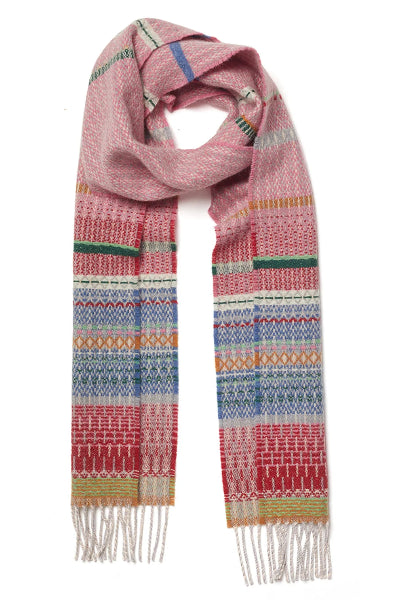 A multicolor patterned knit scarf with fringed ends, featuring horizontal bands of pink, red, blue, green, and yellow geometric and Fair Isle style motifs on a white background.