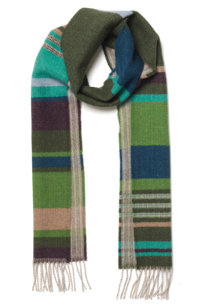 A multicolor striped wool scarf with fringe ends, featuring blocks of green, teal, navy, purple, and beige on a white background.