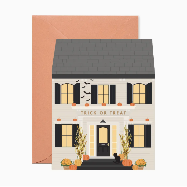 Halloween-themed greeting card with a house illustration and 'Trick or Treat' text, accompanied by a brown envelope.