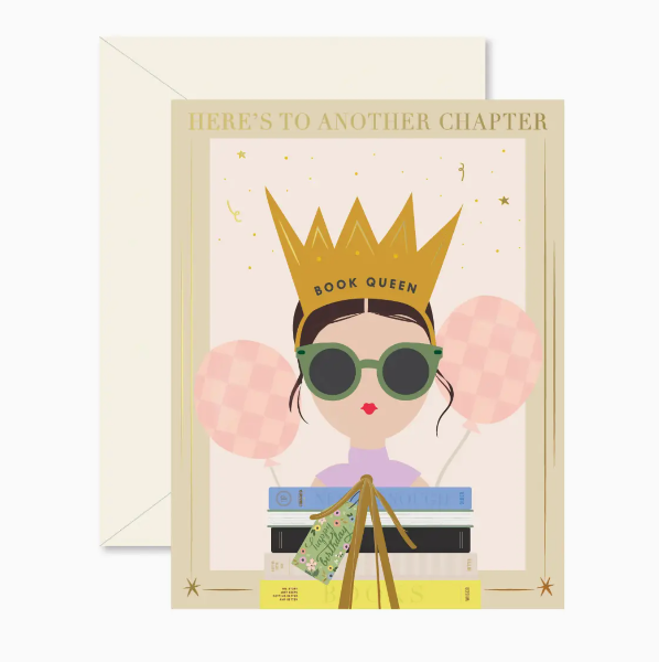 Greeting card with illustration of a woman wearing a crown and sunglasses, surrounded by books and balloons, with 'Here's to another chapter' text.