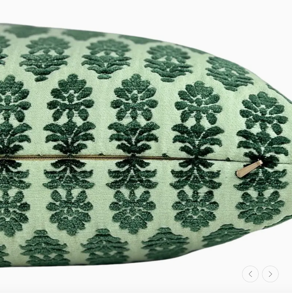 Decorative pillow with green floral pattern on a light green background