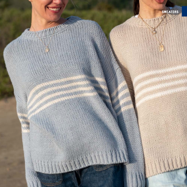 Two people wearing striped sweaters outdoors with a blurred background
