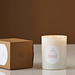Candle labeled 'Harvest Pumpkin' next to its packaging on a brown background