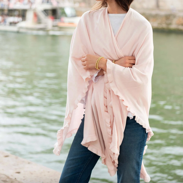 Person wearing a light pink scarf with a blurred water background
