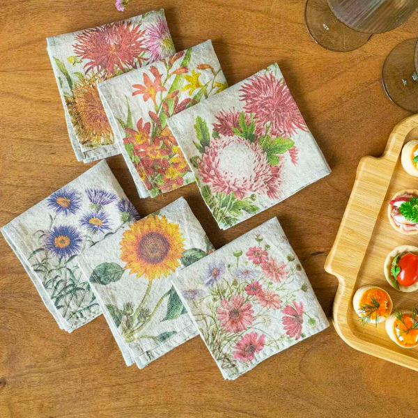 Floral-patterned napkins on a wooden table with a tray of appetizers.