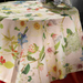 Floral-patterned tablecloth on a table with a decorative bowl of flowers.