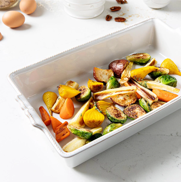 Roasted vegetables in a white baking dish on a light surface