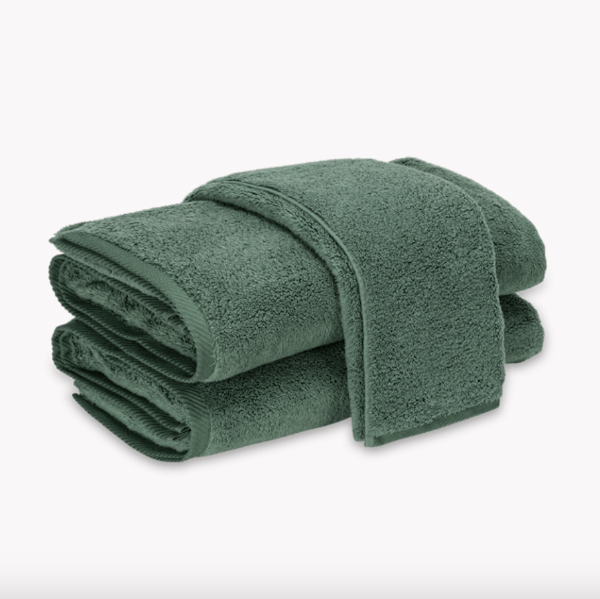 Folded green towel on a white background