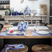 Kitchen with wooden island, blue and white teapot, and various kitchen items.
