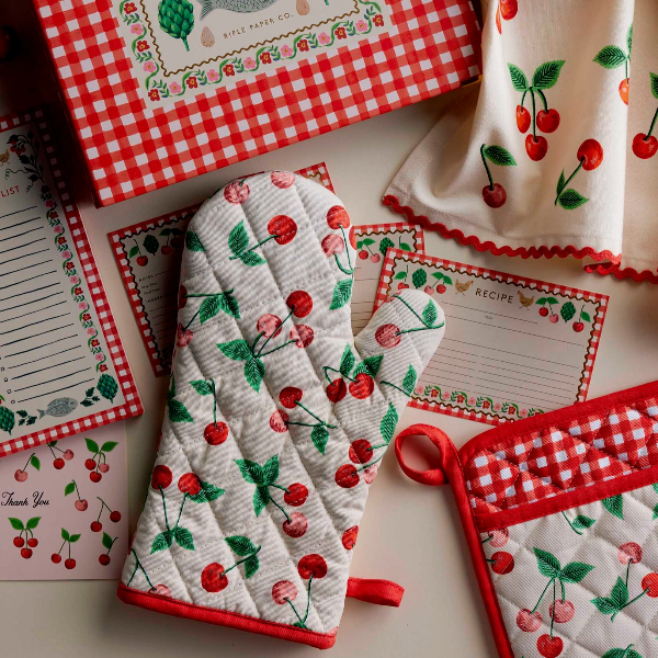Set of kitchen items with cherry pattern including oven mitts, pot holders, and recipe cards.