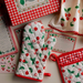 Set of kitchen items with cherry pattern including oven mitts, pot holders, and recipe cards.