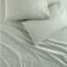 Striped bed sheets in a light color with a subtle pattern