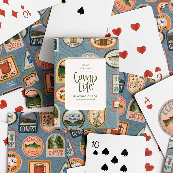 Playing cards with 'Camp Life' design on a blue background with camping-themed illustrations.