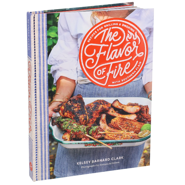 Cookbook titled 'The Flavor of Fire' with a person holding roasted chickens on the cover.
