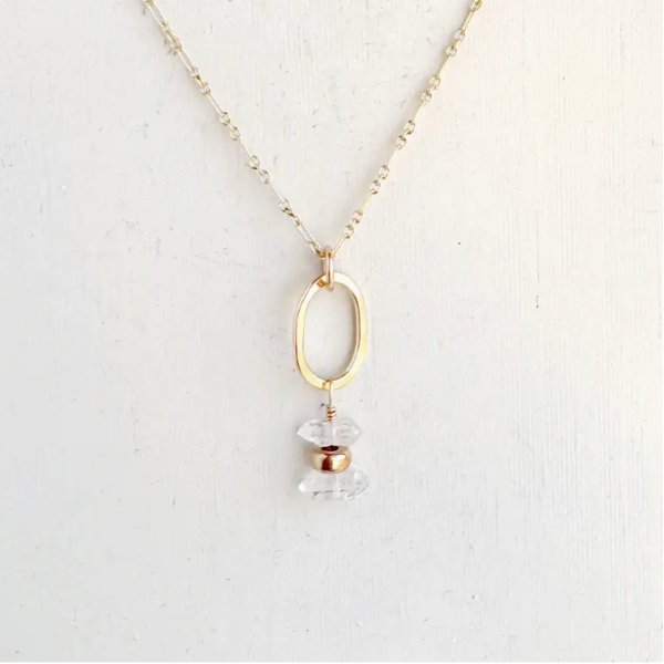 Necklace with a gold pendant and clear crystal on a white background