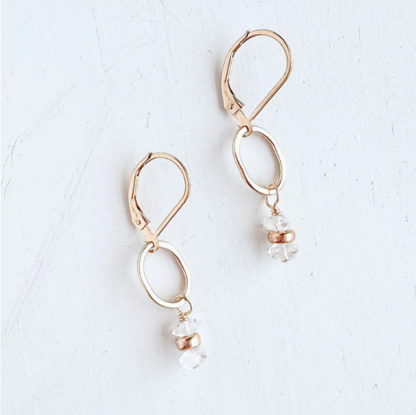 Gold hoop earrings with clear gemstones on a white background