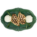 A top-down view of a green scalloped ceramic platter holding two grilled chicken breasts with white mashed potatoes and rosemary sprigs, isolated on a white background.