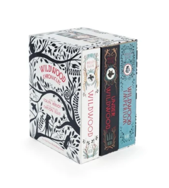 A boxed book set titled Wildwood Chronicles, showing three books partially pulled from the box: Wildwood Chronicles, Under Wildwood, and Wildwood Imperium. The box and book spines feature ornate black and red illustrations on white, with one spine in dark brown and another in light blue.