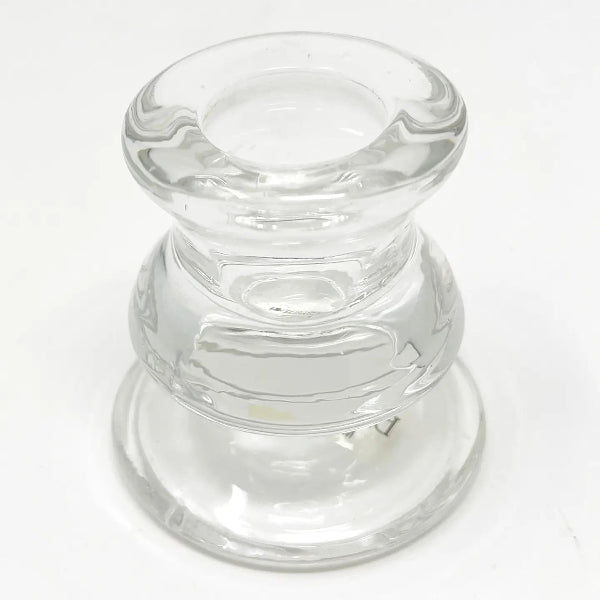 A clear glass candle holder with a tiered, flared design, photographed on a plain white background.