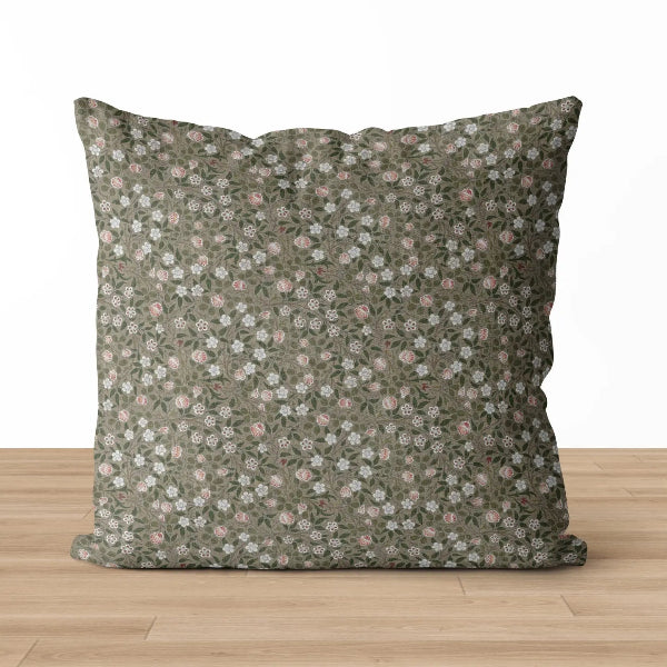 Floral patterned pillow on a wooden surface with a white background