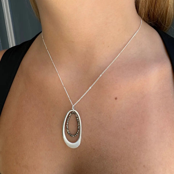 Silver necklace with a pendant on a person's neck