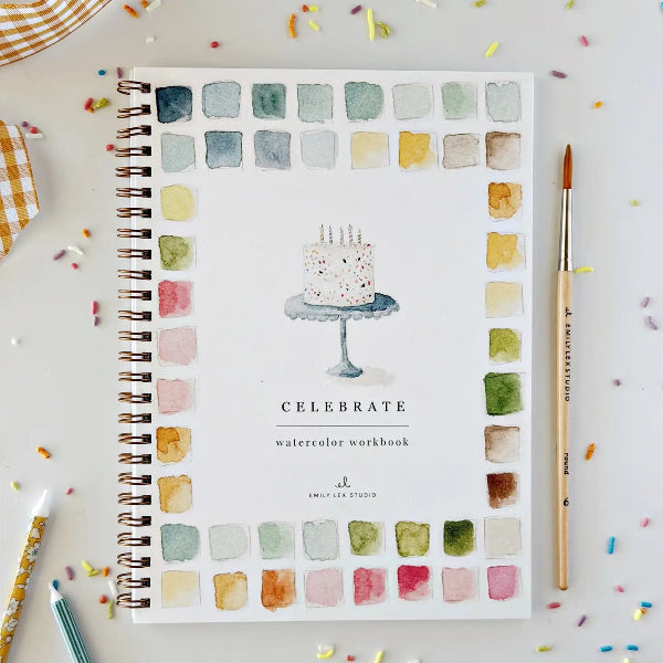 Watercolor workbook titled 'Celebrate' with a cake illustration on a colorful background