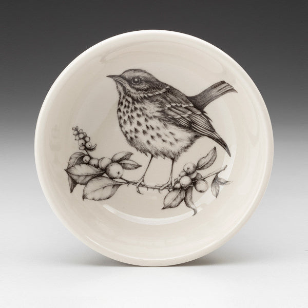Ceramic plate with a bird illustration on a gray background