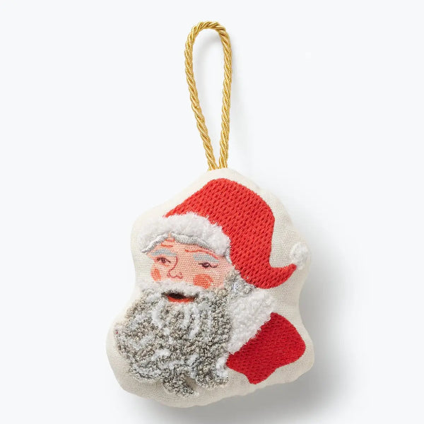 A knitted Christmas ornament shaped like Santa's face, featuring red hat and coat, a white fluffy beard, and a gold hanging loop, shown on a clean white background.