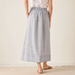 Person wearing a light gray skirt on a plain background