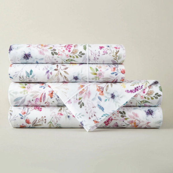Stack of floral-patterned bed sheets on a light gray background