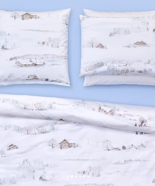 A bedding set with a white background featuring pencil-drawn motifs of winter landscapes, including snow-covered hills and farmhouses.