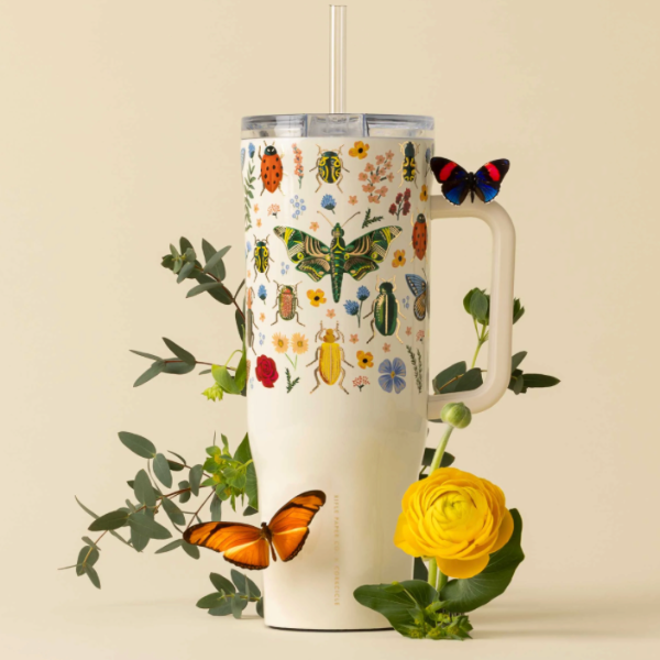 Tumbler with insect and flower design surrounded by butterflies and flowers on a beige background